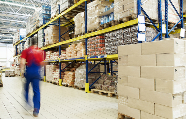 Warehouse worker walking down an aisle.