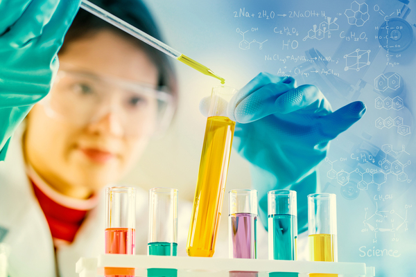 Technician filling glass vials with liquid.