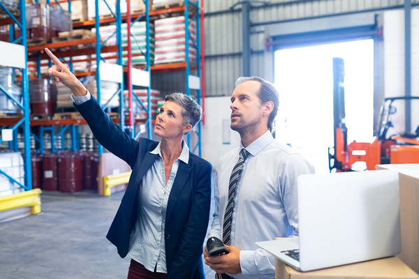 Two people in a warehouse.